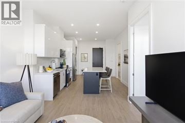 Waterloo condo for rent - A modern living room with a grey sofa and a black television.