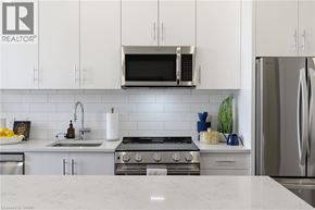 Waterloo condo for rent - A modern kitchen with white cabinets and stainless steel appliances.