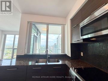 Toronto (Willowdale West) condo for rent - A kitchen with a sink and a window overlooking a cityscape.