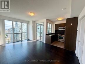 Toronto (Willowdale West) condo for rent - A spacious living room with a view of the cityscape outside the large windows.