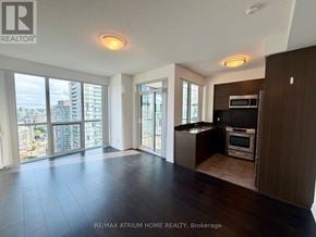 Toronto (Willowdale West) condo for rent - A spacious living room with a view of the cityscape outside the large windows.