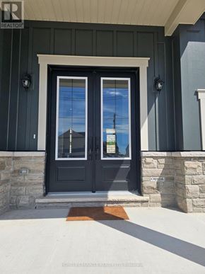 Oro-Medonte apartment for rent - A black double door with a glass window is flanked by two stone pillars.