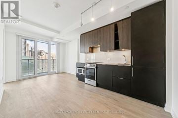 Mississauga (City Centre) condo for rent - A spacious kitchen with black cabinets and a modern design.