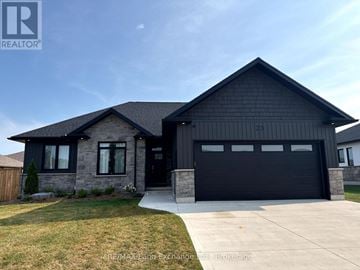 Huron-Kinloss apartment for rent - A modern house with a black garage door is for sale.