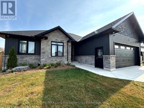 Huron-Kinloss apartment for rent - A modern house with a stone facade and a black garage door.
