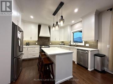 Huron-Kinloss apartment for rent - A kitchen with white cabinets and a wooden floor.