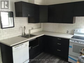 Ottawa apartment for rent - A kitchen with black cabinets and a white dishwasher.