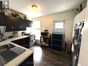 Ottawa apartment for rent - A kitchen with a sink, refrigerator, and a window.