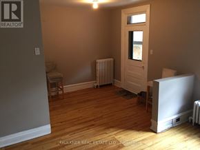 Ottawa apartment for rent - A room with wooden floors and a white door.