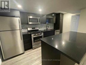 Toronto (Greenwood-Coxwell) apartment for rent - A kitchen with a refrigerator, oven, microwave, and sink.
