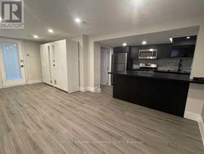 Toronto (Greenwood-Coxwell) apartment for rent - A spacious room with a kitchenette and a bar area.