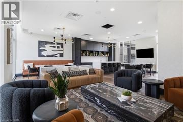 Waterloo condo for rent - A modern living room with a black and white rug, a black coffee table, and a large painting on the wall.