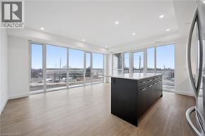 Waterloo condo for rent - A spacious room with a large window overlooking a parking lot.