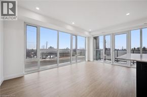 Waterloo condo for rent - A spacious room with a large window and a wooden floor.