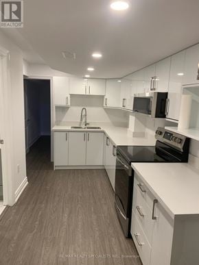 Vaughan (Kleinburg) apartment for rent - A modern kitchen with white cabinets and black appliances.