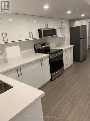 Vaughan (Kleinburg) apartment for rent - A modern kitchen with white cabinets and stainless steel appliances.