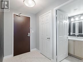 Mississauga (City Centre) condo for rent - A white bathroom with a brown door and a white cabinet.