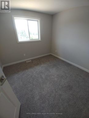 Tillsonburg townhouse for rent - A room with a carpeted floor and a window.