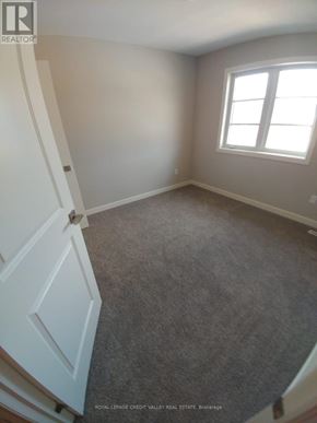 Tillsonburg townhouse for rent - A room with a carpeted floor and a window.