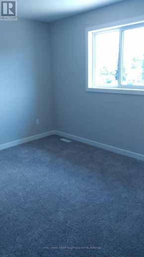 Tillsonburg townhouse for rent - A room with a window and carpeted floor.