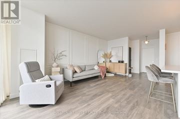 Toronto (Mount Pleasant West) condo for rent - A well-lit, spacious living room with a grey sofa and a white armchair.