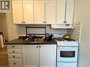 Hamilton apartment for rent - A kitchen with white cabinets and a black countertop.