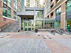 Toronto (Little Portugal) condo for rent - A modern building entrance with a glass wall and a metal staircase.