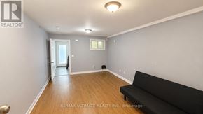 Toronto (Palmerston-Little Italy) apartment for rent - A living room with a black couch and a doorway leading to another room.