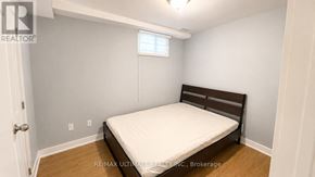 Toronto (Palmerston-Little Italy) apartment for rent - A bedroom with a bed, wooden headboard, and a window.