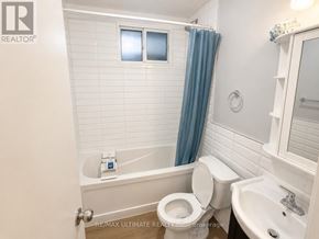 Toronto (Palmerston-Little Italy) apartment for rent - A white toilet with a blue shower curtain in a bathroom.