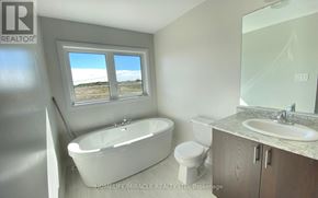 Innisfil (Alcona) apartment for rent - A bathroom with a tub, toilet, sink, and a window.