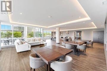 Brampton (Queen Street Corridor) condo for rent - A spacious living room with a large wooden table and white chairs.