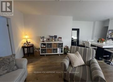 Hamilton (North End) apartment for rent - A living room with a grey couch and a wooden floor.