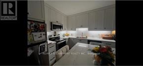 Hamilton (North End) apartment for rent - A kitchen with white cabinets and a fridge.