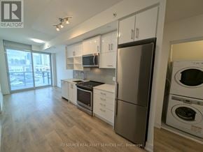 Toronto (Don Valley Village) condo for rent - A modern kitchen with stainless steel appliances and white cabinets.
