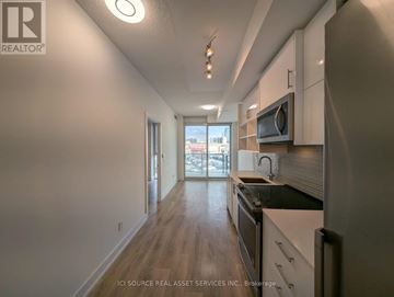 Toronto (Don Valley Village) condo for rent - A kitchen with white cabinets and a black countertop.