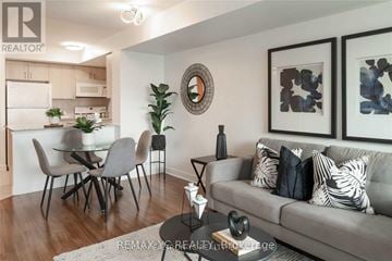 Toronto (Willowdale East) condo for rent - A living room with a grey couch and a dining table with chairs.