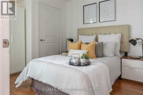 Toronto (Willowdale East) condo for rent - A bedroom with a bed, nightstand, and two framed pictures on the wall.