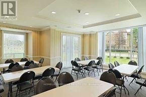 Toronto (Malvern) condo for rent - A conference room with tables and chairs and a window with curtains.