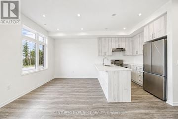 Richmond Hill townhouse for rent - A kitchen with white cabinets and a wooden island.