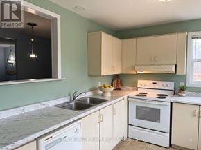 London East (East H) townhouse for rent - A kitchen with white appliances and a marble countertop.