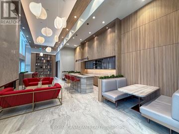 Toronto (York University Heights) condo for rent - A modern living room with a red sofa and a bar area.