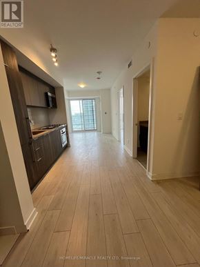 Toronto (Agincourt South-Malvern West) condo for rent - A spacious hallway with wooden flooring and a modern kitchen area.