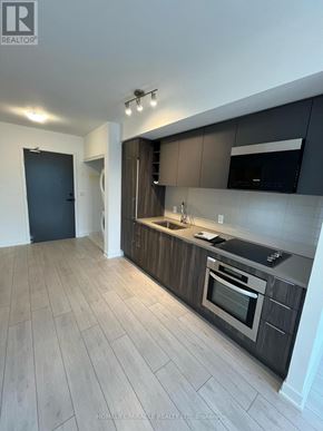 Toronto (Agincourt South-Malvern West) condo for rent - A modern kitchen with dark wood cabinets and stainless steel appliances.