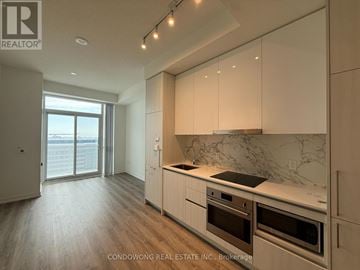 Vaughan (Concord) condo for rent - A modern kitchen with white cabinets and a marble backsplash.