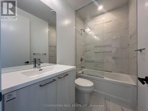Vaughan (Concord) condo for rent - A white bathroom with a glass shower stall and a toilet.