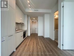 Vaughan (Concord) condo for rent - A kitchen with white cabinets and a wooden floor.