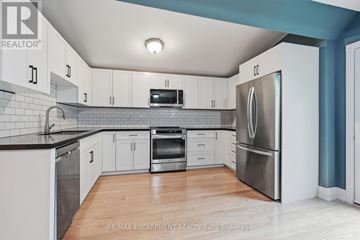 Hamilton (Kirkendall) apartment for rent - A kitchen with white cabinets and a stainless steel refrigerator.