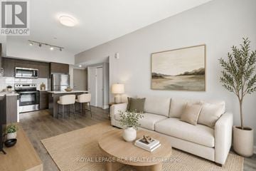 Barrie (Little Lake) condo for rent - A living room with a couch, a coffee table, and a painting on the wall.