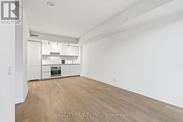Toronto (Thorncliffe Park) condo for rent - A spacious kitchen with white cabinets and a wooden floor.